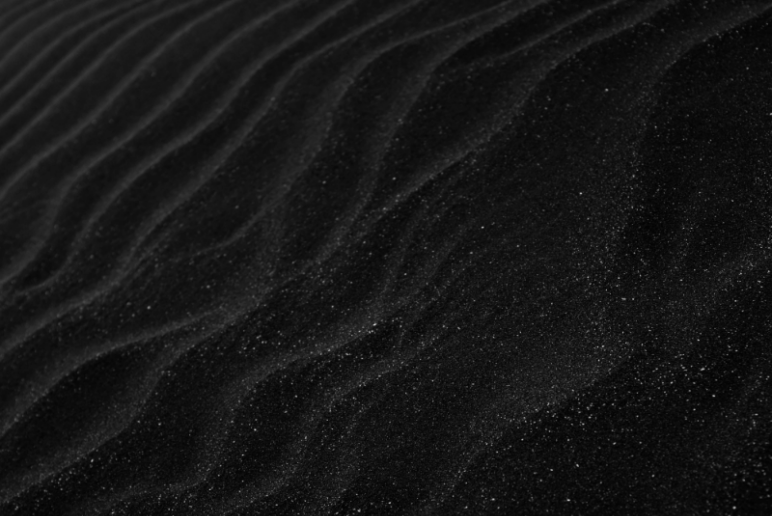 A black and white photo of a sand dune.